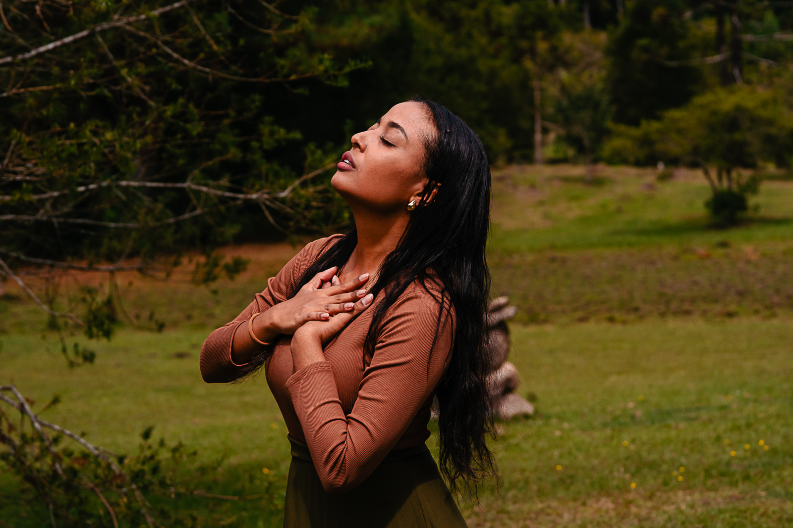 Mulher em conexão com a natureza, mãos no coração