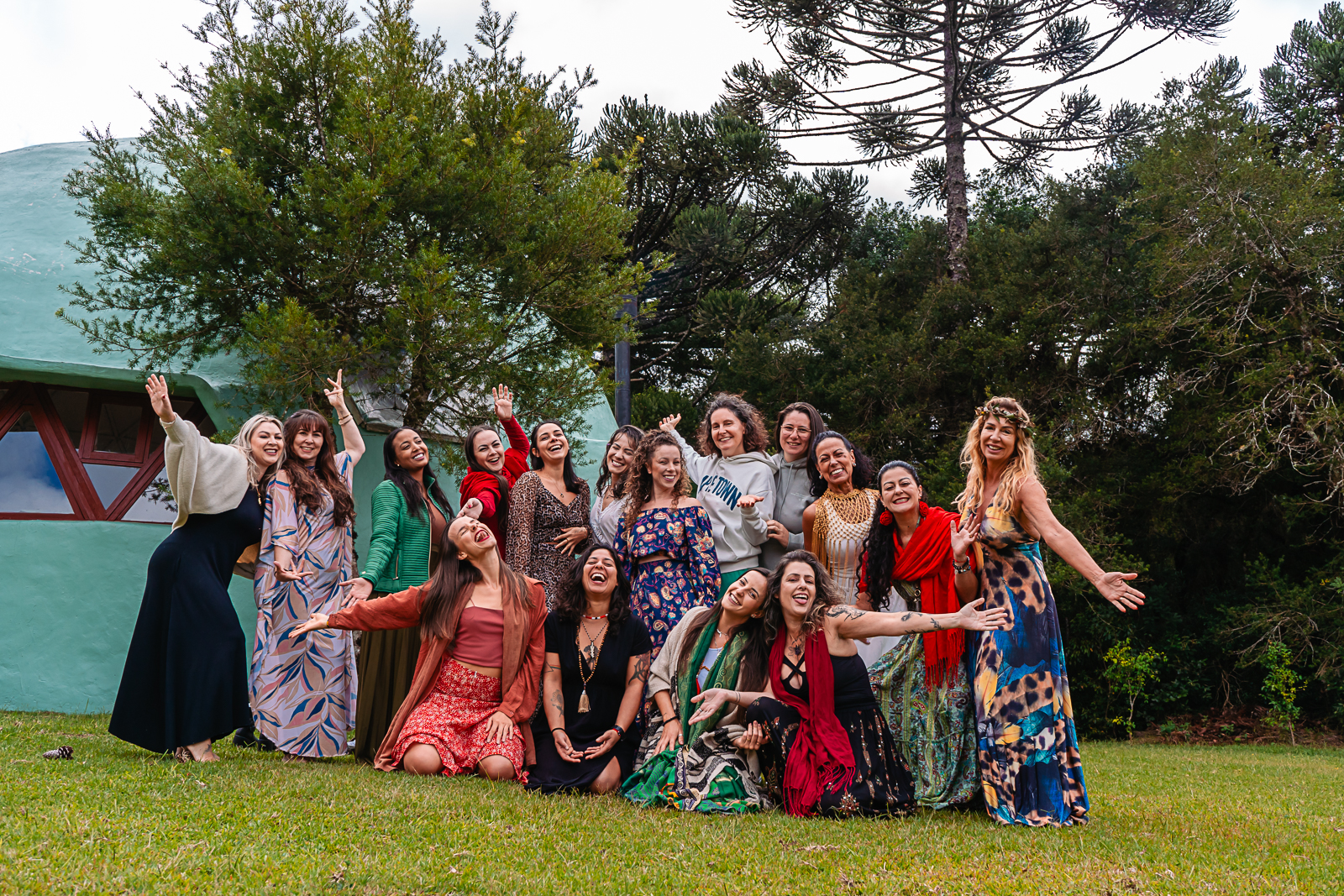 Grupo de mulheres celebrando juntas em frente ao domo geodésico